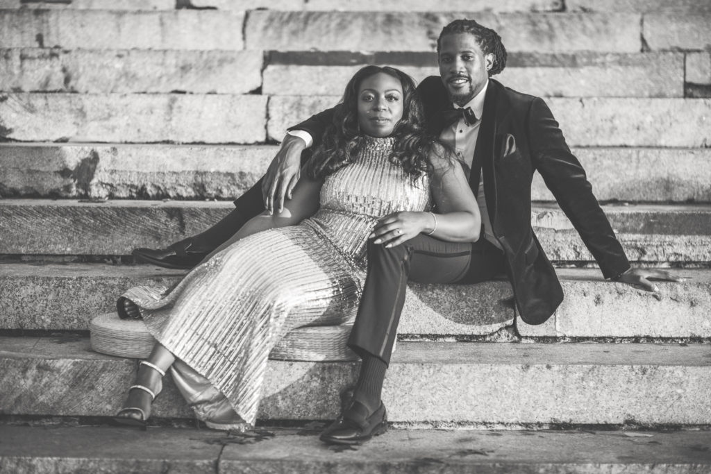 Black Couple in Formal Attire sitting on steps at Brooklyn Bridge Park, Pier 1.