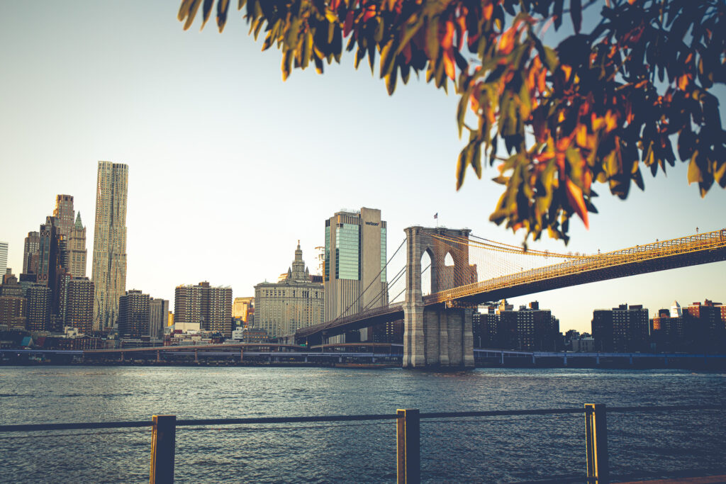 Brooklyn Bridge with autumn foliage and New York City skyline, ideal for outdoor wedding photography.