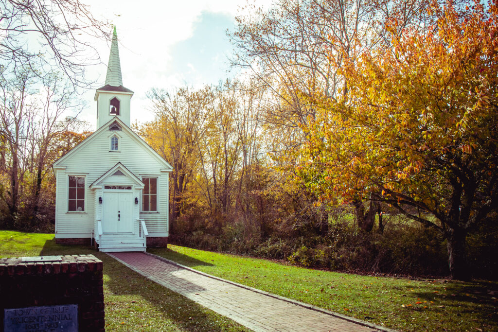 Quaint white chapel at Islip Grange Park surrounded by fall colors, a picturesque location for intimate outdoor wedding photography.
