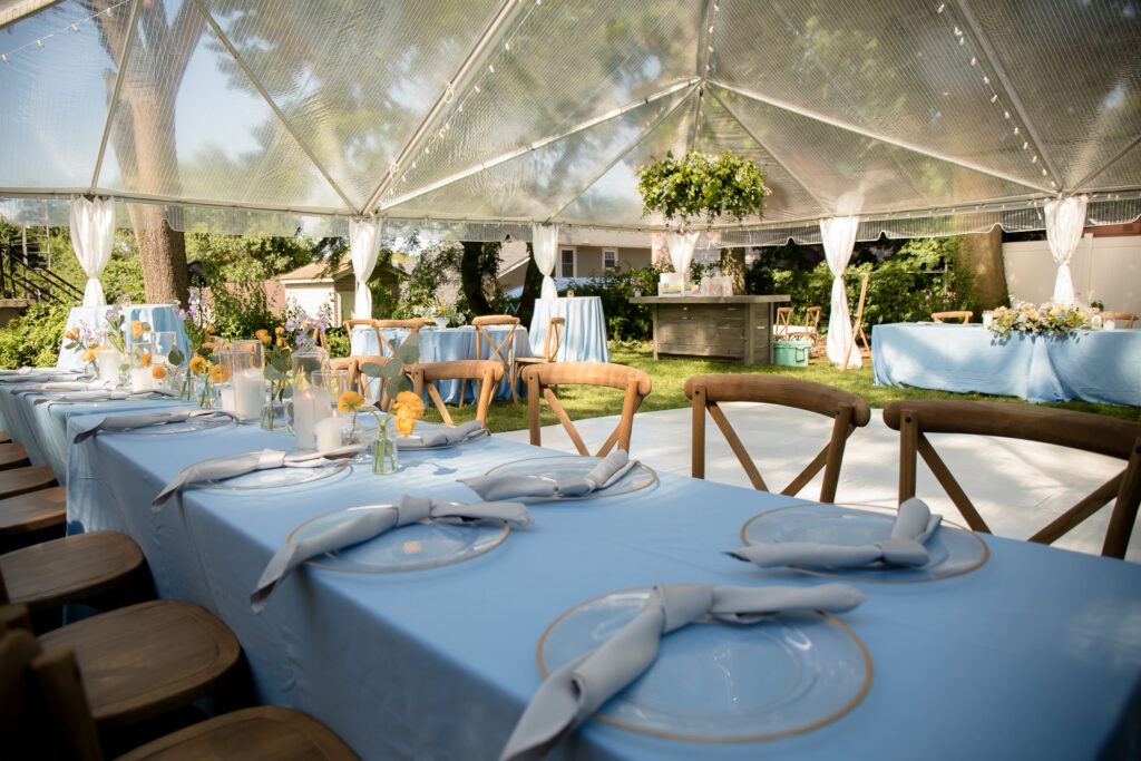 Elegantly set dining tables under a transparent tent for a micro-wedding.