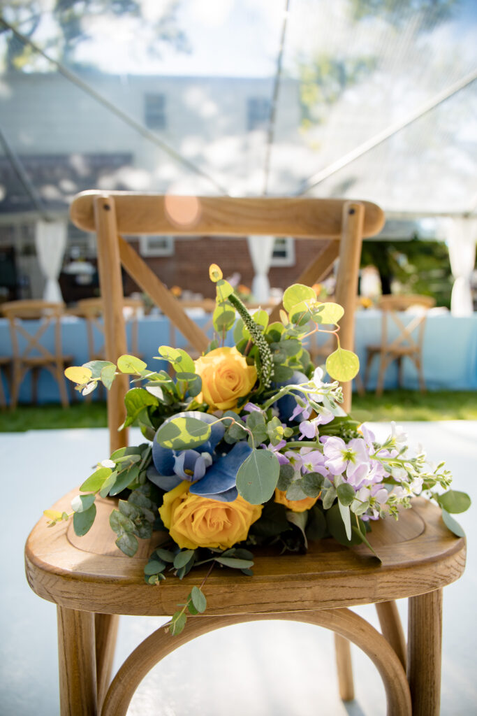 Bridal bouquet on a wooden chair at a garden micro-wedding.
